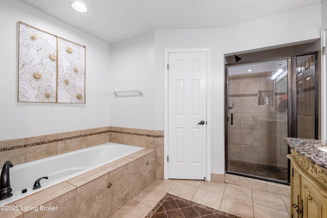 bathroom with a bath, a shower stall, recessed lighting, vanity, and tile patterned flooring