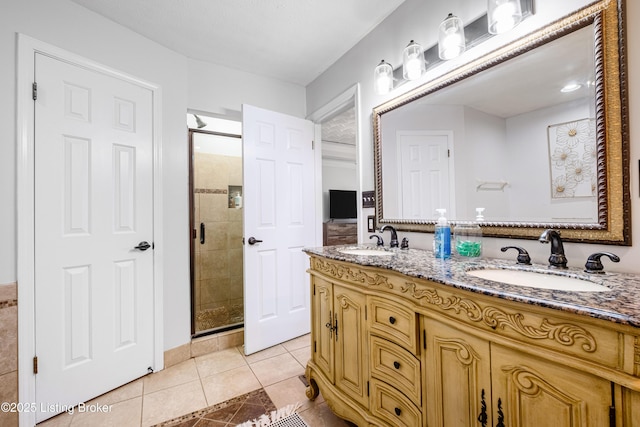 full bath featuring a sink, tile patterned floors, a shower stall, and double vanity