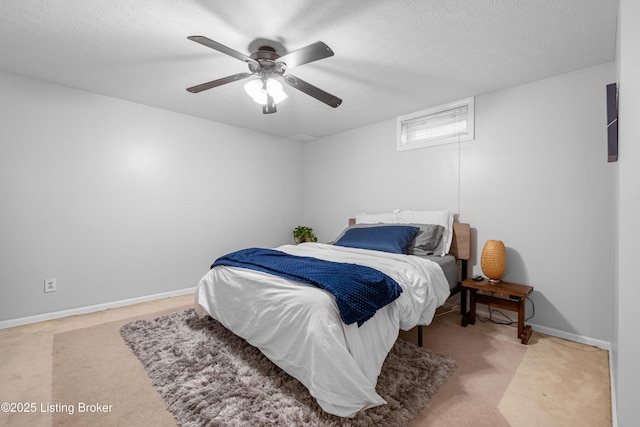 carpeted bedroom with a textured ceiling, ceiling fan, and baseboards