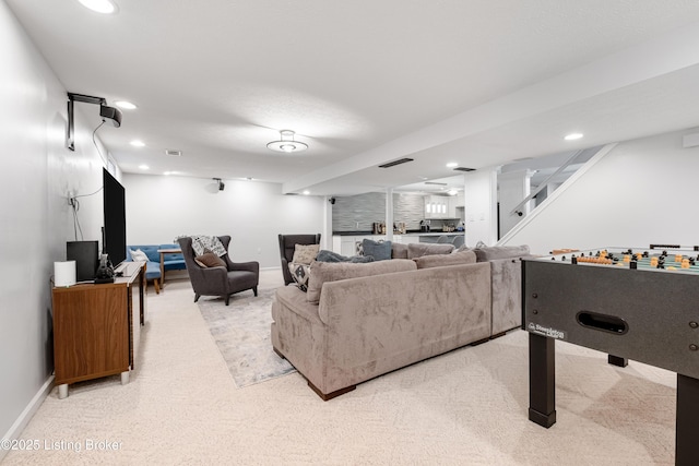 living area featuring recessed lighting, light carpet, and stairs