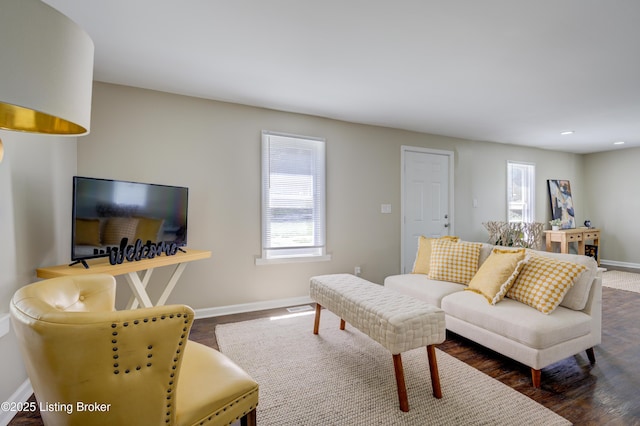 living room with dark wood-style flooring, baseboards, and visible vents