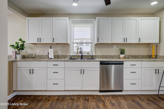 kitchen with light stone counters, dishwasher, a sink, and white cabinets