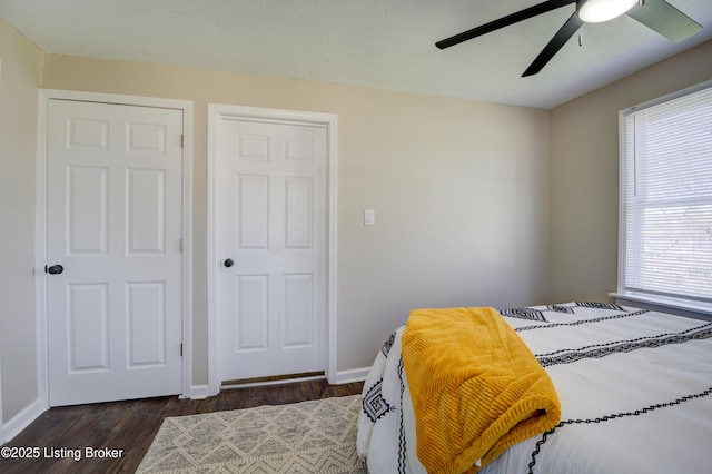 bedroom featuring dark wood-type flooring, ceiling fan, and baseboards