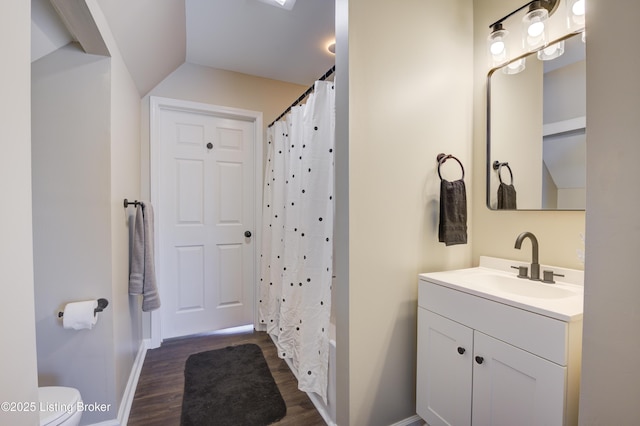bathroom featuring baseboards, a shower with curtain, toilet, vanity, and wood finished floors