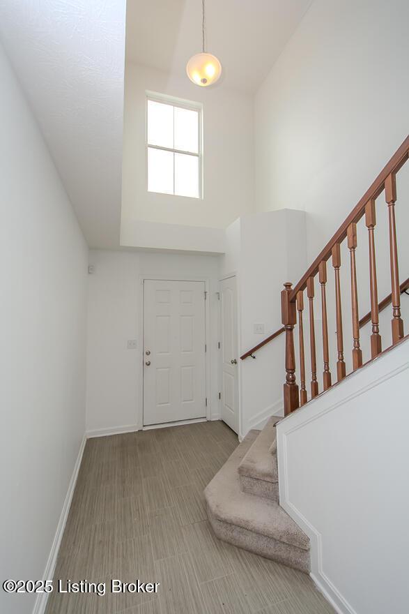 11207 Comfort Ct, Louisville, KY 40229 - foyer entrance with high vaulted ceiling, stairs, and baseboards
