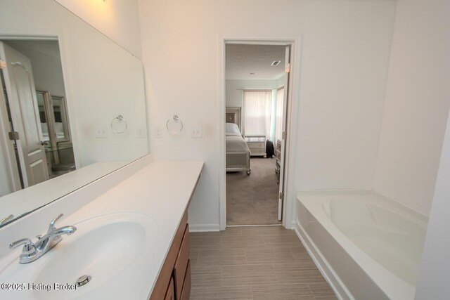11207 Comfort Ct, Louisville, KY 40229 - full bathroom with vanity, a tub, connected bathroom, and baseboards
