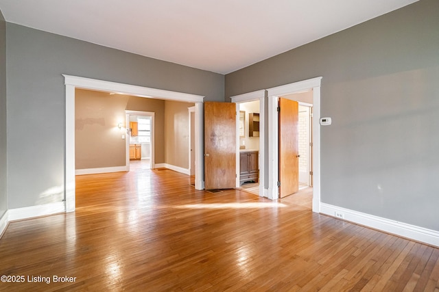 empty room with light wood-style floors and baseboards