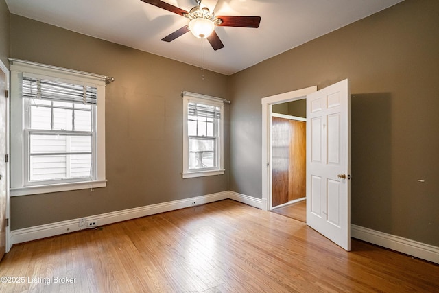 unfurnished bedroom with light wood-type flooring, baseboards, and a ceiling fan