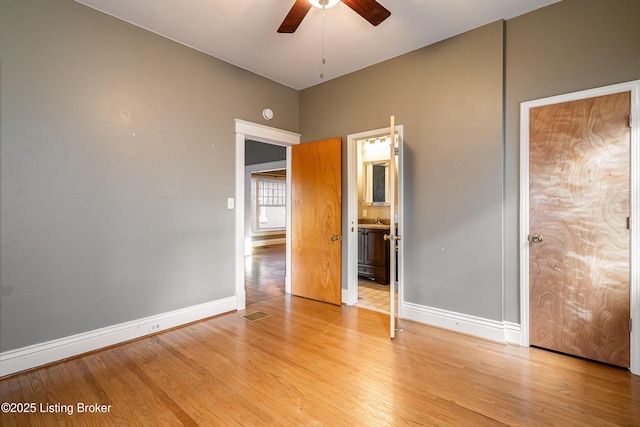unfurnished bedroom with visible vents, light wood-type flooring, baseboards, and ensuite bathroom