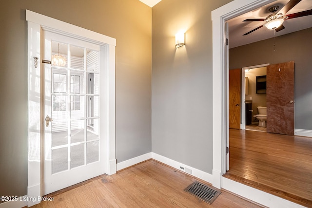 interior space featuring visible vents, ceiling fan, wood finished floors, and baseboards