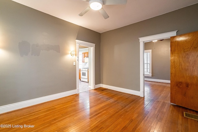 unfurnished room with light wood-type flooring, ceiling fan, baseboards, and visible vents