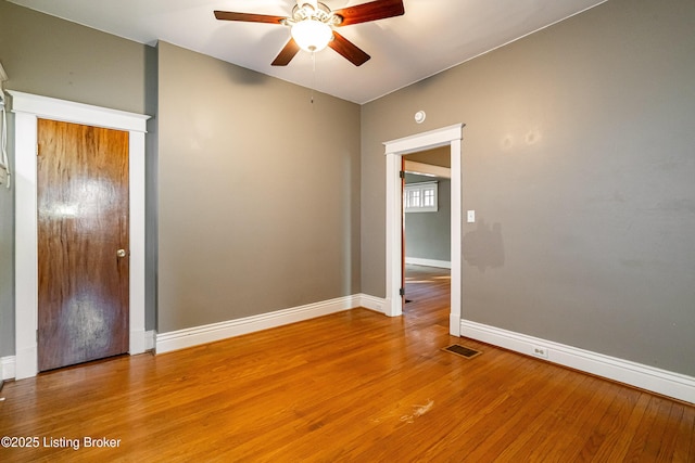 spare room with visible vents, ceiling fan, light wood finished floors, and baseboards