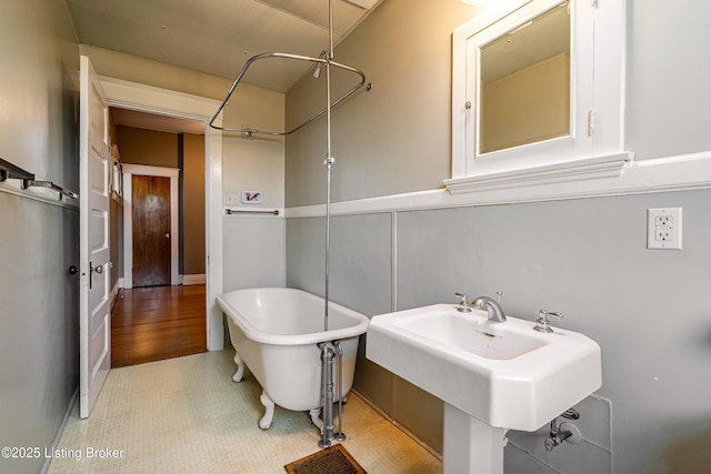 full bath featuring a sink and a soaking tub