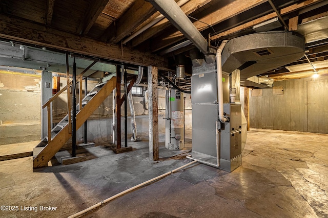 unfinished below grade area featuring water heater, visible vents, heating unit, and stairs