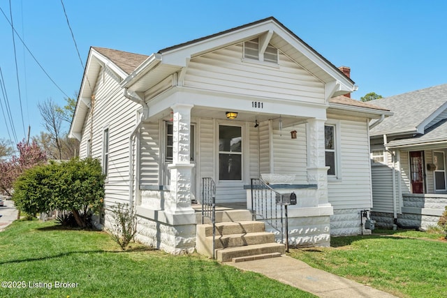 view of front of home featuring a front lawn, covered porch, and a chimney