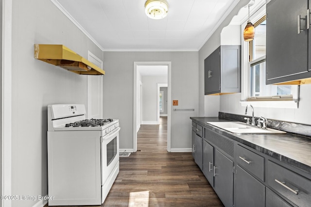 kitchen featuring crown molding, gas range gas stove, gray cabinets, dark wood-style flooring, and dark countertops