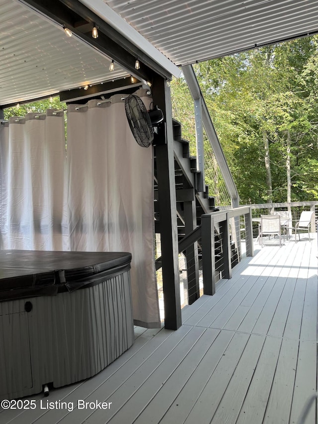 wooden deck featuring a hot tub and stairway
