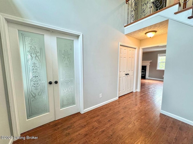 interior space with baseboards, french doors, and wood finished floors