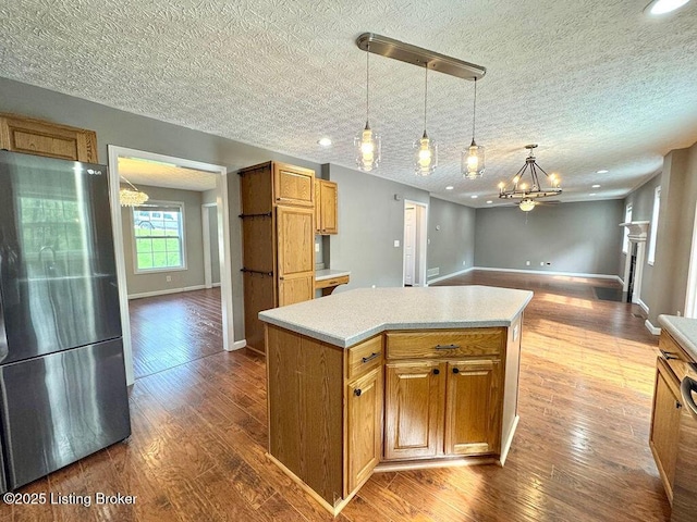 kitchen featuring freestanding refrigerator, a notable chandelier, light countertops, and baseboards
