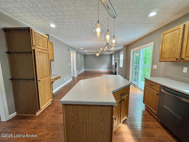 kitchen featuring dishwasher, light countertops, dark wood-type flooring, and pendant lighting