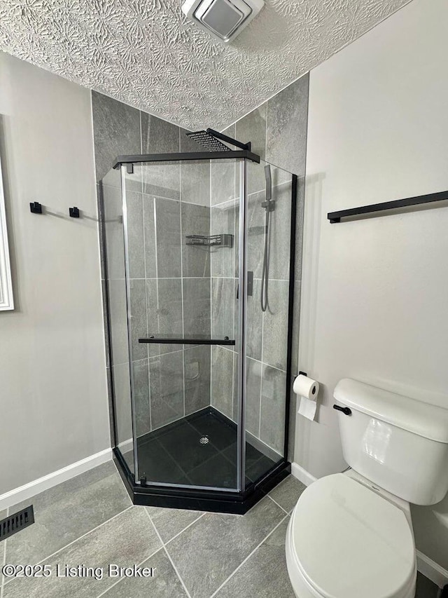 bathroom featuring toilet, baseboards, visible vents, and a shower stall