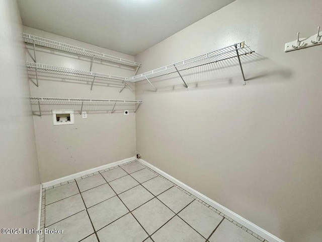 clothes washing area featuring light tile patterned floors, laundry area, washer hookup, hookup for an electric dryer, and baseboards