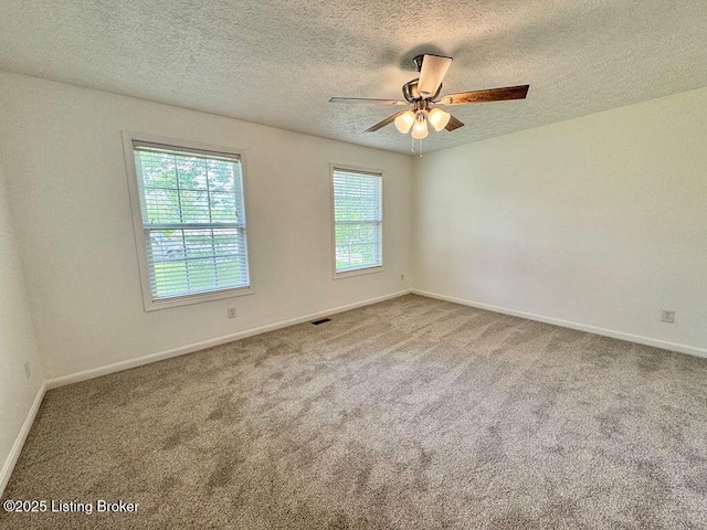 unfurnished room featuring a textured ceiling, carpet flooring, and baseboards
