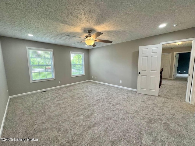 empty room featuring carpet floors, a ceiling fan, and baseboards