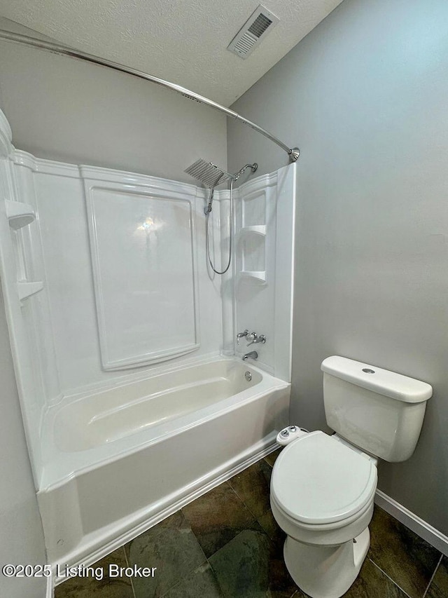 full bathroom featuring toilet, a textured ceiling, visible vents, washtub / shower combination, and baseboards
