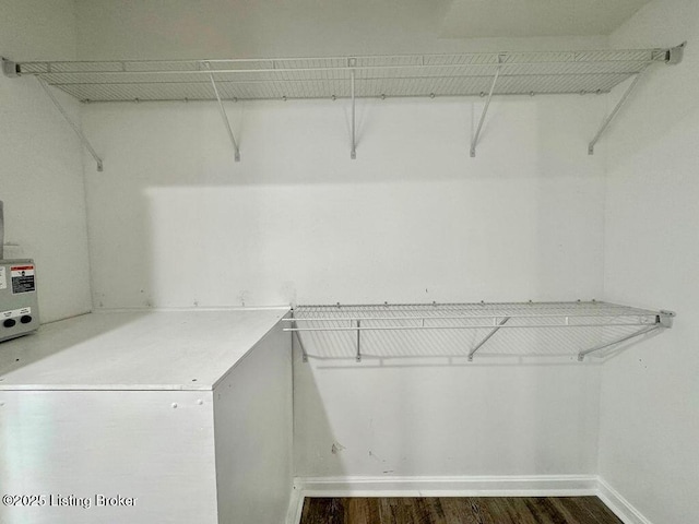 spacious closet with dark wood finished floors