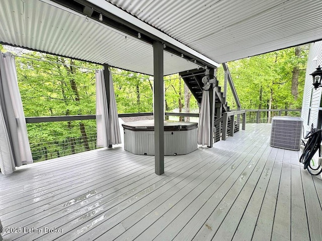 wooden deck featuring a hot tub and central air condition unit