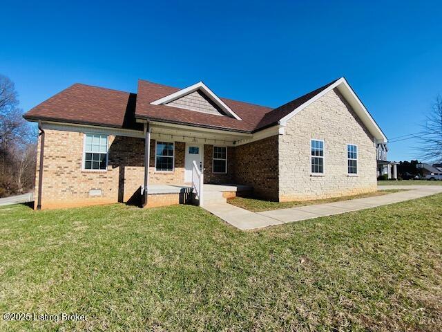 view of front of property with a front yard, a porch, and brick siding
