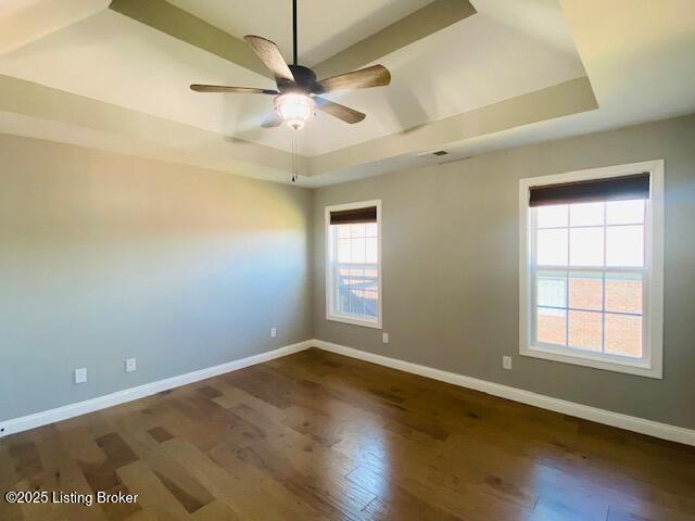 spare room with a raised ceiling and baseboards