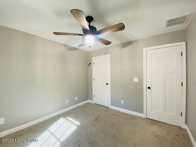 unfurnished bedroom with a ceiling fan, baseboards, carpet, and visible vents