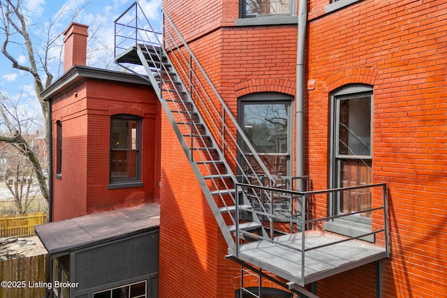 1026 S Brook St, Louisville, KY 40203 - view of side of home with a chimney, a balcony, fence, and brick siding