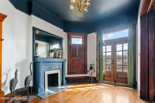 1026 S Brook St, Louisville, KY 40203 - entryway with a tiled fireplace, wood-type flooring, baseboards, and an inviting chandelier