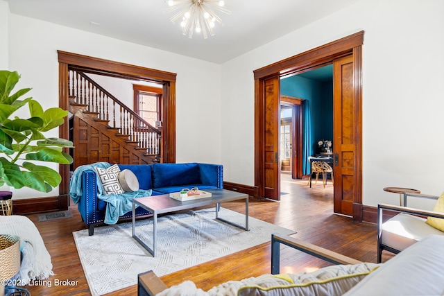 1026 S Brook St, Louisville, KY 40203 - living room featuring an inviting chandelier, visible vents, wood finished floors, stairs, and baseboards