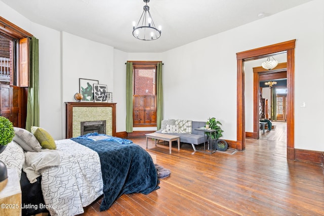 1026 S Brook St, Louisville, KY 40203 - bedroom with a fireplace, a notable chandelier, baseboards, and wood finished floors
