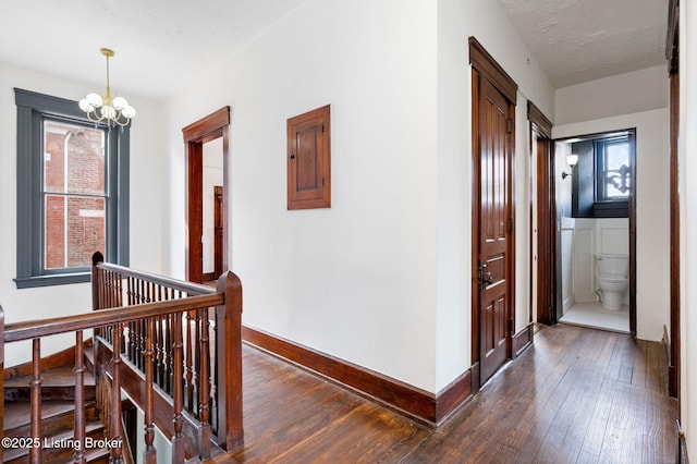 1026 S Brook St, Louisville, KY 40203 - corridor featuring a notable chandelier, an upstairs landing, dark wood-style flooring, and baseboards