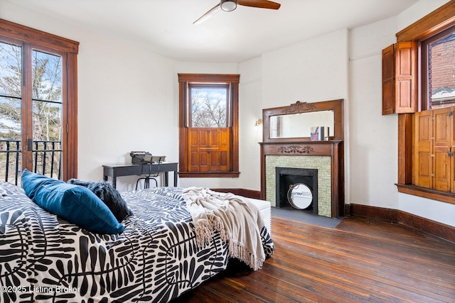 1026 S Brook St, Louisville, KY 40203 - bedroom featuring baseboards, multiple windows, a fireplace with flush hearth, and dark wood-style floors