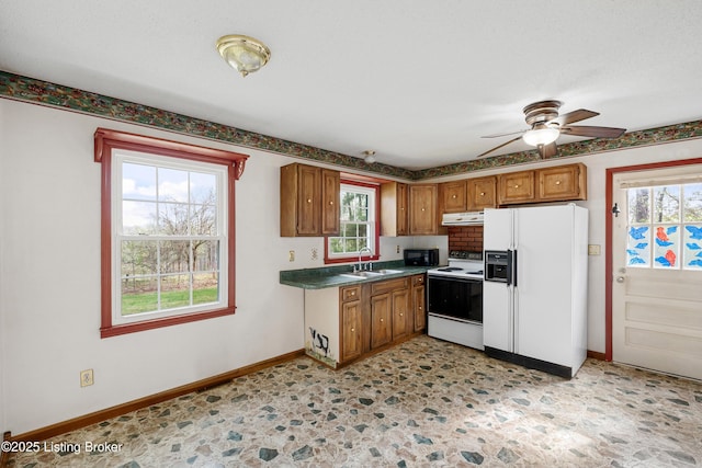 kitchen featuring white fridge with ice dispenser, a ceiling fan, exhaust hood, range with electric cooktop, and a sink