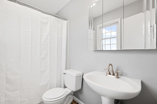 full bath featuring a sink, toilet, and curtained shower