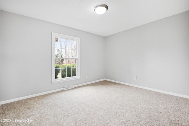 carpeted spare room featuring visible vents and baseboards