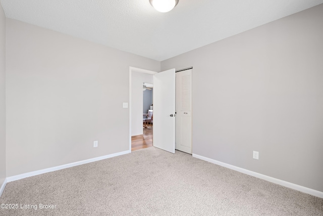 empty room with light carpet and baseboards