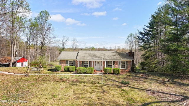 ranch-style home with a chimney, covered porch, a front lawn, and brick siding