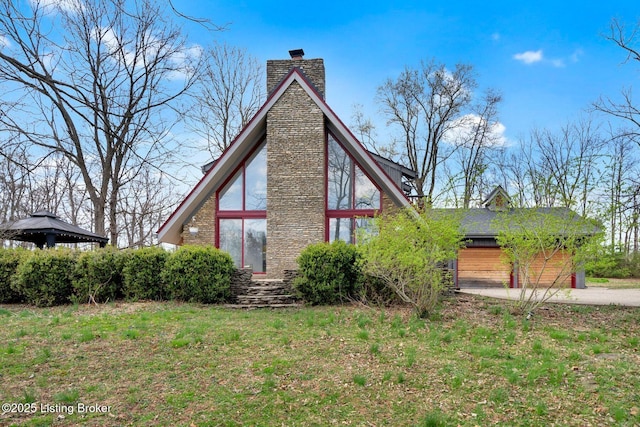 view of side of property featuring a gazebo and a chimney