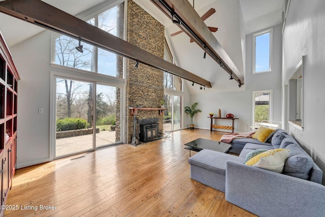 living room with high vaulted ceiling, beamed ceiling, light wood-style floors, and visible vents
