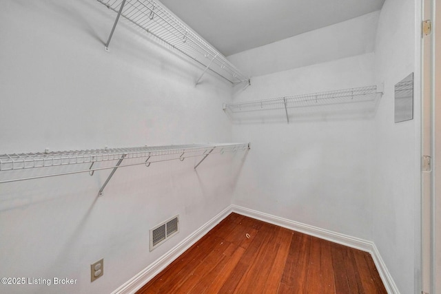 spacious closet with dark wood-type flooring and visible vents