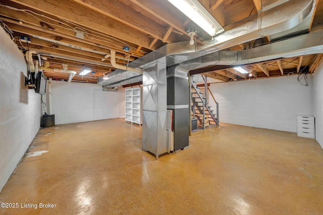 unfinished basement featuring stairs and heating unit
