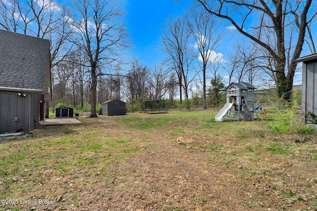 view of yard featuring an outdoor structure, a playground, and a shed